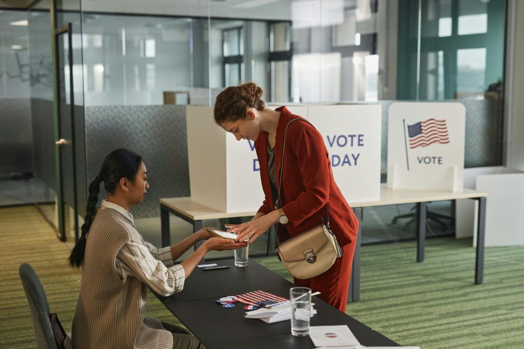 Two people are shown at a voting location