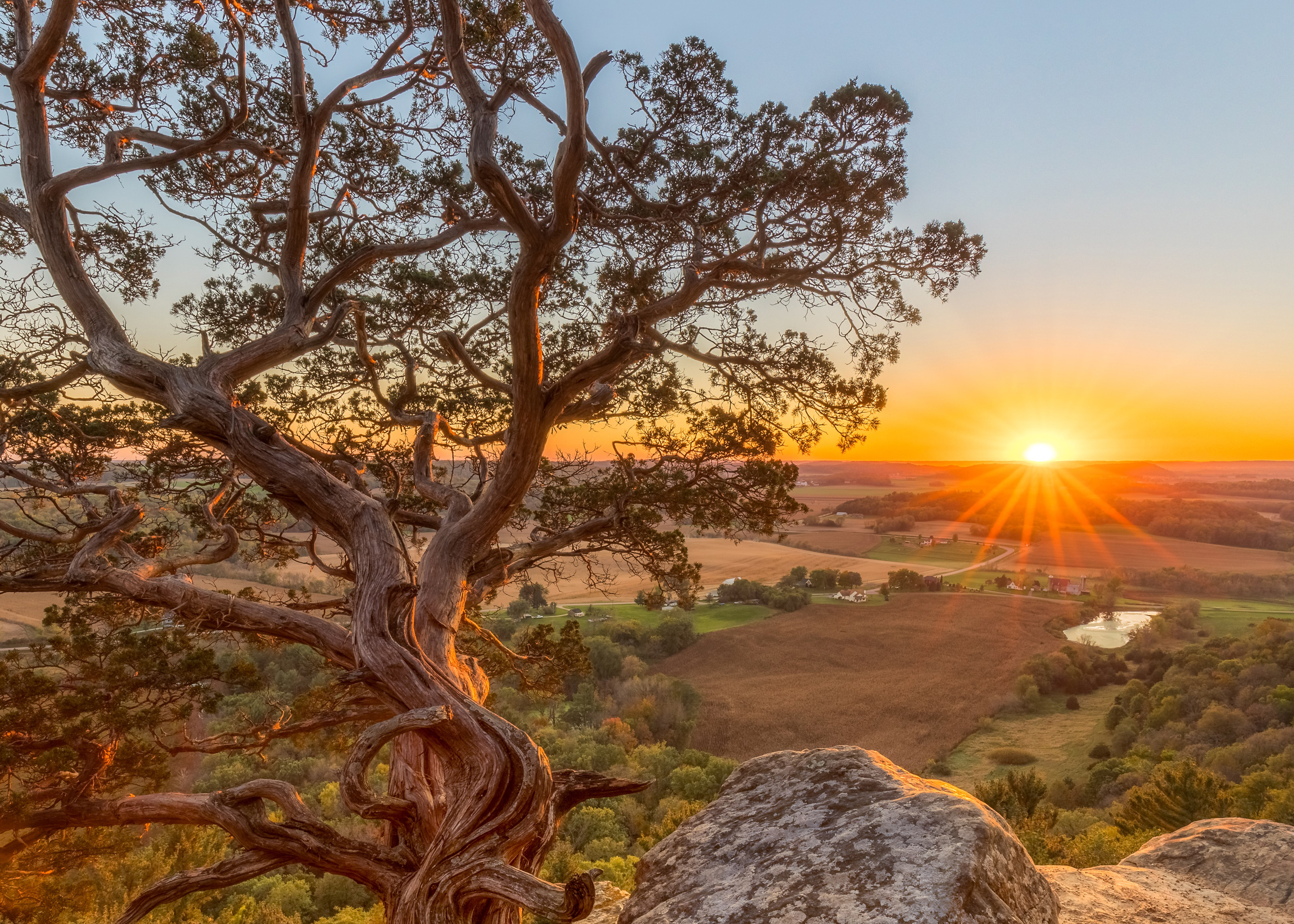 A scenic view of the sun rising over fields in Wisconsin.